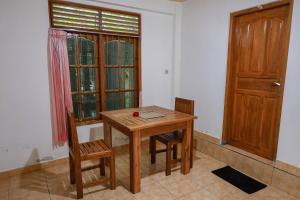 a wooden table and two chairs in a room at The Kori Homestay in Munduk