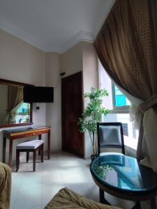 a living room with a glass table and a chair at Hotel Maamoura in Casablanca