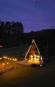 a glass house is lit up at night at The hideout peaks in Bhīm Tāl +6 photos
