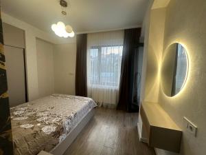 a bedroom with a bed and a window at GM Apartment in Tbilisi City
