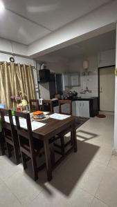 a kitchen and dining room with a wooden table and chairs at Sungava homestay in Mirik