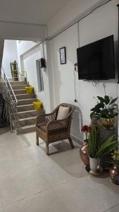 a living room with a chair and a tv on the wall at Sungava homestay in Mirik