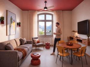 a man standing in a living room with a window at DAFFY Hôtel in Briançon