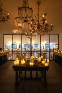 a table with candles and plates and chandeliers at Grand Hôtel De Cala Rossa & Spa Nucca in Porto-Vecchio +225 photos