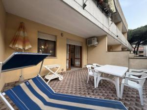 a patio with a table and chairs and an umbrella at Residenza Emilia in Lido degli Estensi