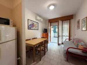 a kitchen and dining room with a table and a refrigerator at Residenza Emilia in Lido degli Estensi