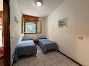 a room with two beds and a window at Residenza Emilia in Lido degli Estensi