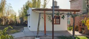 a small white house with the door open at Palo Blanco in Cinco Saltos