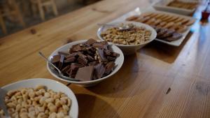 a wooden table with three bowls of chocolate and peanuts at Les Eres de Guardiolans in Vilada