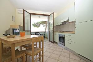 a kitchen with a table and a refrigerator at Smith 3B in Lido degli Estensi