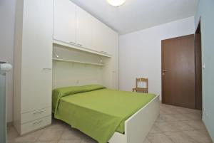 a bedroom with a green bed in a white room at Smith 3B in Lido degli Estensi