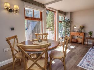 a dining room with a table and chairs and a window at Captains Barn in Tiverton