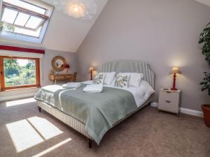 a bedroom with a large bed and a window at Captains Barn in Tiverton