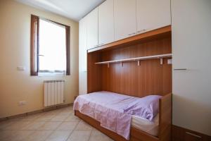 a bedroom with a bed and a window at Sul Mare Smith in Lido degli Estensi