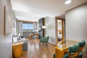 a hotel room with a living area with a table and chairs at Hotel Brasil 21 Suites, Affiliated by Meliá in Brasília