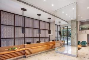 a lobby with a reception desk and chairs at Hotel Brasil 21 Suites, Affiliated by Meliá in Brasília