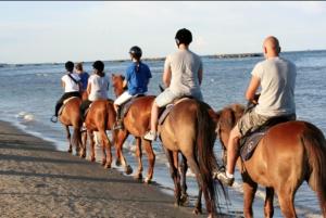 a group of people riding horses on the beach at VILLA TASSO 25 BILO in Lido degli Estensi