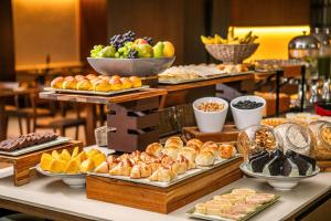 a buffet of different types of food on a table at Hotel Brasil 21 Suites, Affiliated by Meliá in Brasília