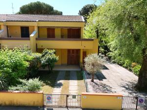 a yellow house with a fence in front of it at Villette Astoria in Lido degli Estensi