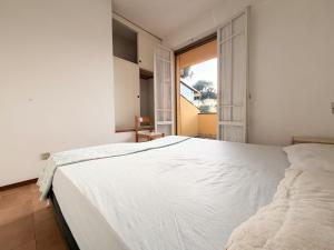 a bedroom with a large white bed and a window at Villette Astoria in Lido degli Estensi