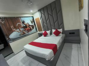 a bedroom with a large bed with a movie projected on the wall at Hotel Satyam in Vadodara