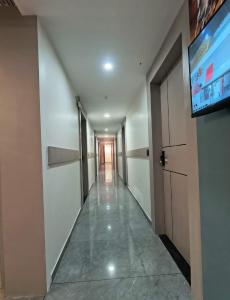 a hallway with a flat screen tv in a building at Hotel Satyam in Vadodara