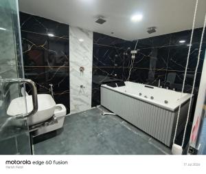 a bathroom with a bath tub and a toilet at Hotel Satyam in Vadodara