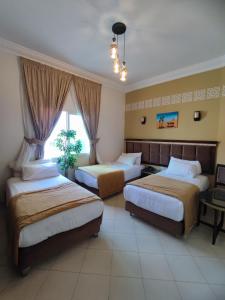 a hotel room with two beds and a window at Hotel Maamoura in Casablanca
