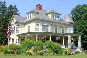 a large house with a flag in front of it at Cornerstone Victorian Bed and Breakfast in Warrensburg