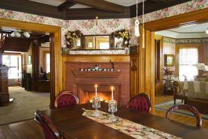 a dining room with a table and a fireplace at Cornerstone Victorian Bed and Breakfast in Warrensburg +3 photos