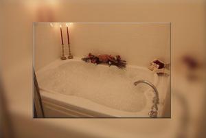 a bath tub with two candles in a bathroom at Cornerstone Victorian Bed and Breakfast in Warrensburg