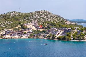 a small boat in the water in front of a mountain at Mobile Home Altura Luxury Sea View Retreat in Drage