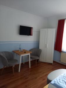 a room with a table and two chairs and a television at Lindenzimmer Stöcken in Oetzen