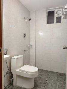 a white bathroom with a toilet and a shower at CR RIVERA in Madurai
