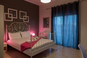 a bedroom with a bed with a lamp and blue curtains at Electra Apartments & Studios 2 in Keramoti