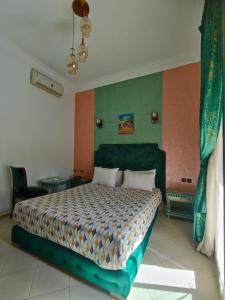 a bedroom with a bed and a green wall at Hotel Maamoura in Casablanca +16 photos