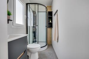 a bathroom with a toilet and a glass shower at Mobile Home Altura Luxury Sea View Retreat in Drage