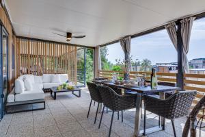 a patio with a table and chairs and a couch at Mobile Home Altura Luxury Sea View Retreat in Drage +58 photos