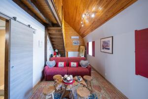 a living room with a red couch and a table at Chambres D'hôtes Histoire D'anges in Singles