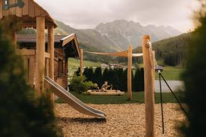 a playground with a slide in front of a house at FRÄULEIN NANNERL - Boutique Apart mit Saunahaus in Gerlos