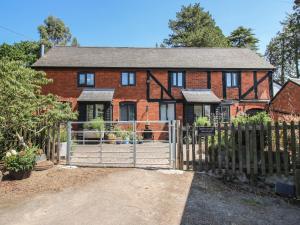 a brick house with a gate and a fence at Chess Cottage in Hereford