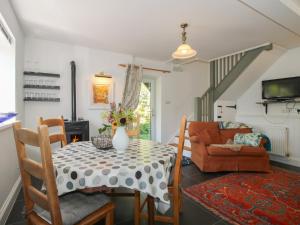 a dining room with a table with a vase on it at Chess Cottage in Hereford