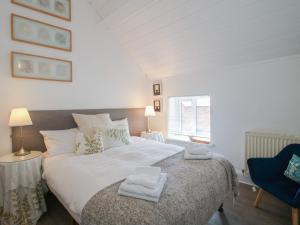 a bedroom with a large bed with towels on it at Chess Cottage in Hereford