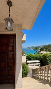 a door to a house with a view of the ocean at Villa Aldán Areacova in Aldán