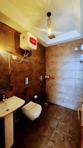 a bathroom with a toilet and a sink at Kali Tibba Resort Chail in Chail +51 photos