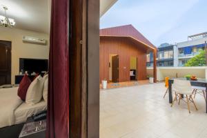 a room with a bed and a table with chairs at Nook Inn & Suites - 2 Min Walk From MG ROAD METRO in Gurgaon