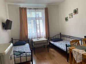 a room with two beds and a table and a window at Flat in Center Teplice in Teplice