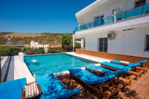 a villa with a swimming pool with blue furniture at Villa Abiori in Ksamil