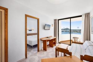 a living room with a couch and a table at TRH Jardín Del Mar in Santa Ponsa