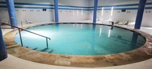 ein großes Becken mit blauem Wasser in einem Gebäude in der Unterkunft hôtel Benkachour in Oujda